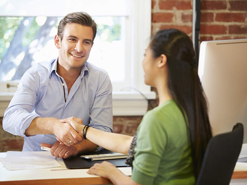 CPA shaking hands with a client at a desk