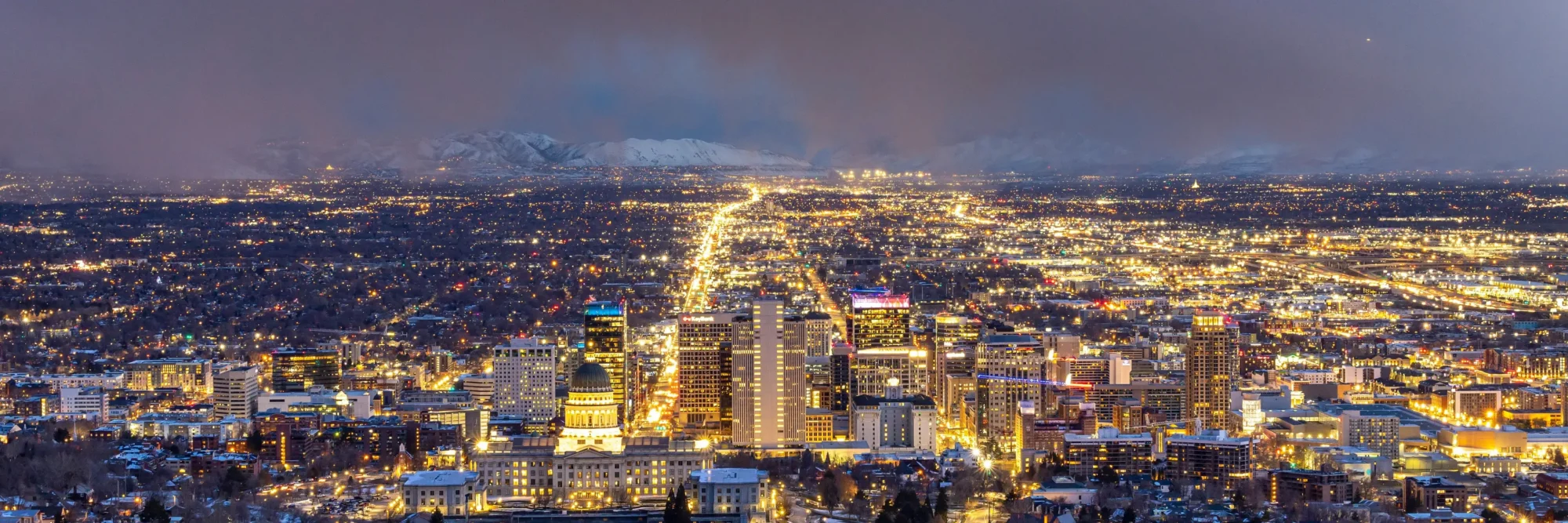 Salt lake city skyline in the night-time during winter. Clouds in the distances.